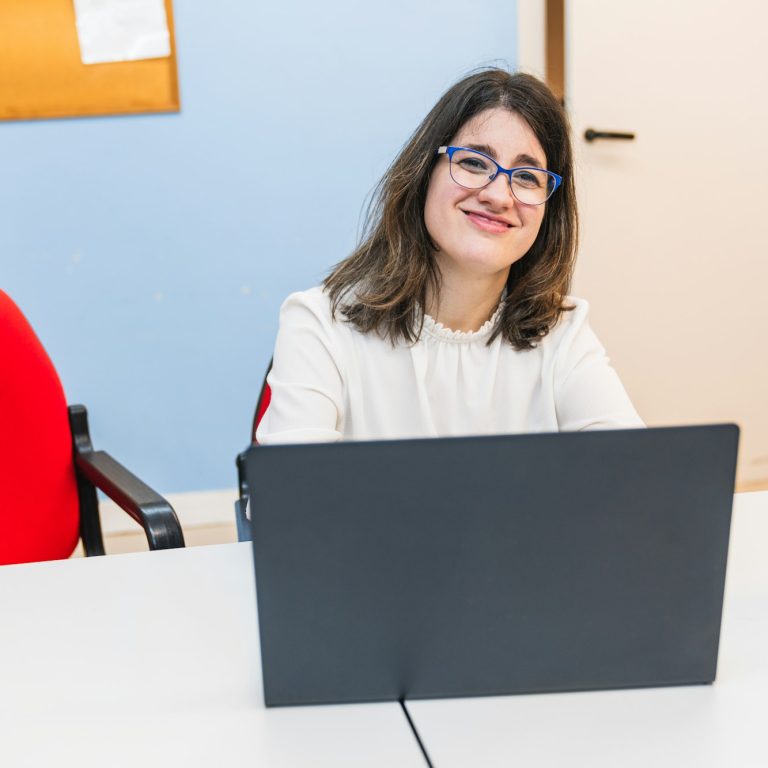 Cheerful Young Woman with Disability Smiling at Her Desk
